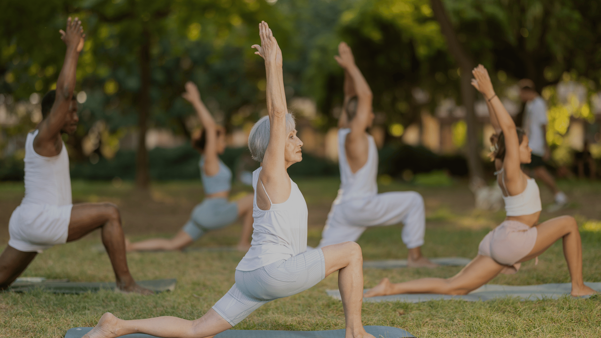 a group of people doing yoga poses in a park