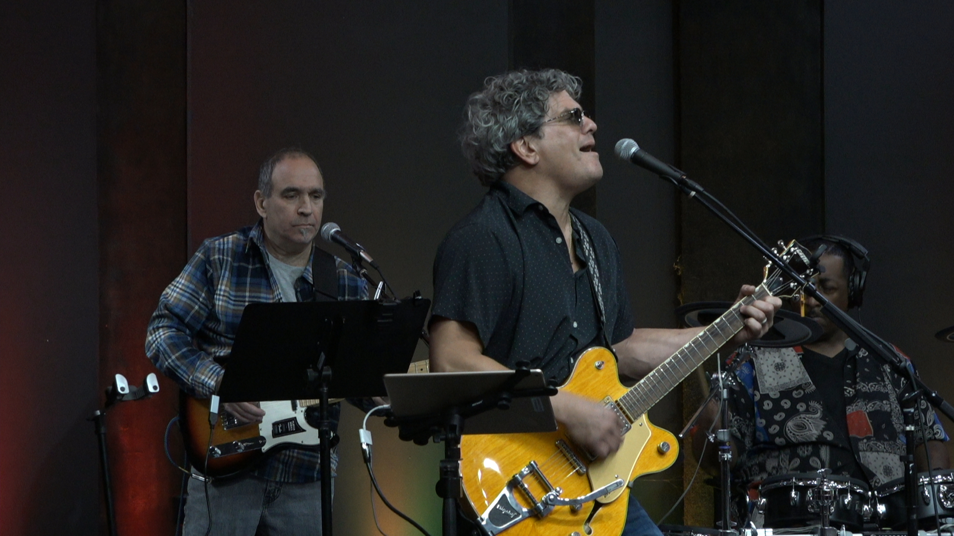 Sonny Cashbaugh playing guitar and singing into a microphone