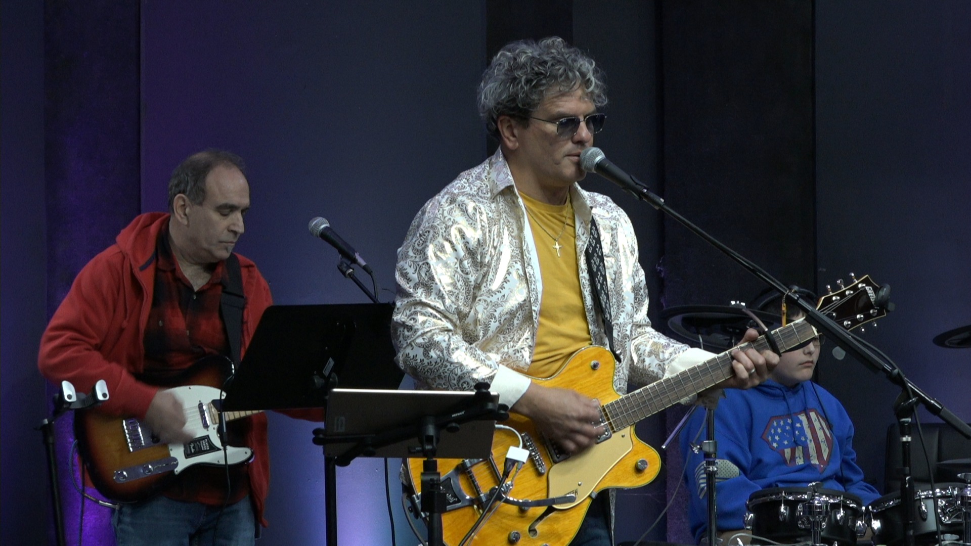 Sonny Cashbaugh playing guitar and singing into a microphone