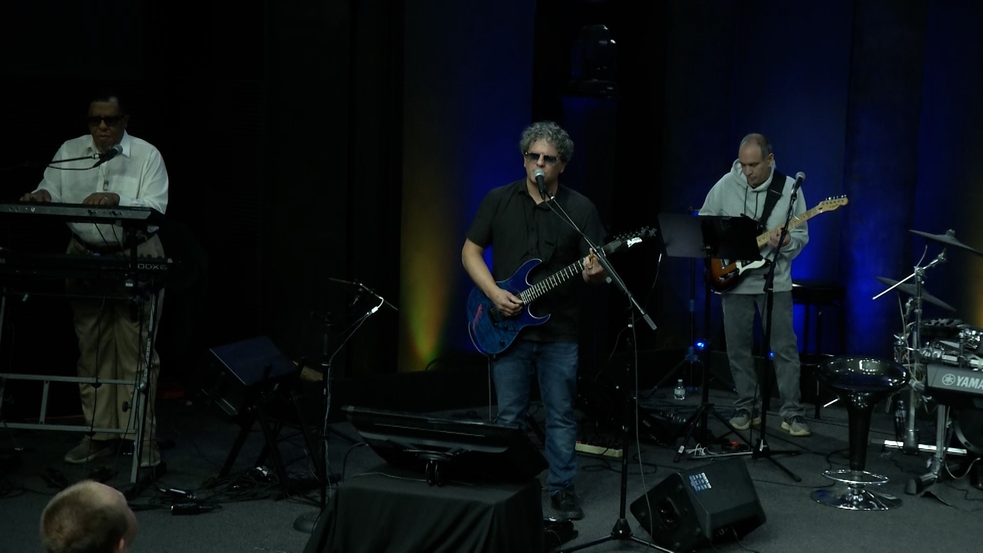 Sonny Cashbaugh and a band of musicians playing instruments on stage