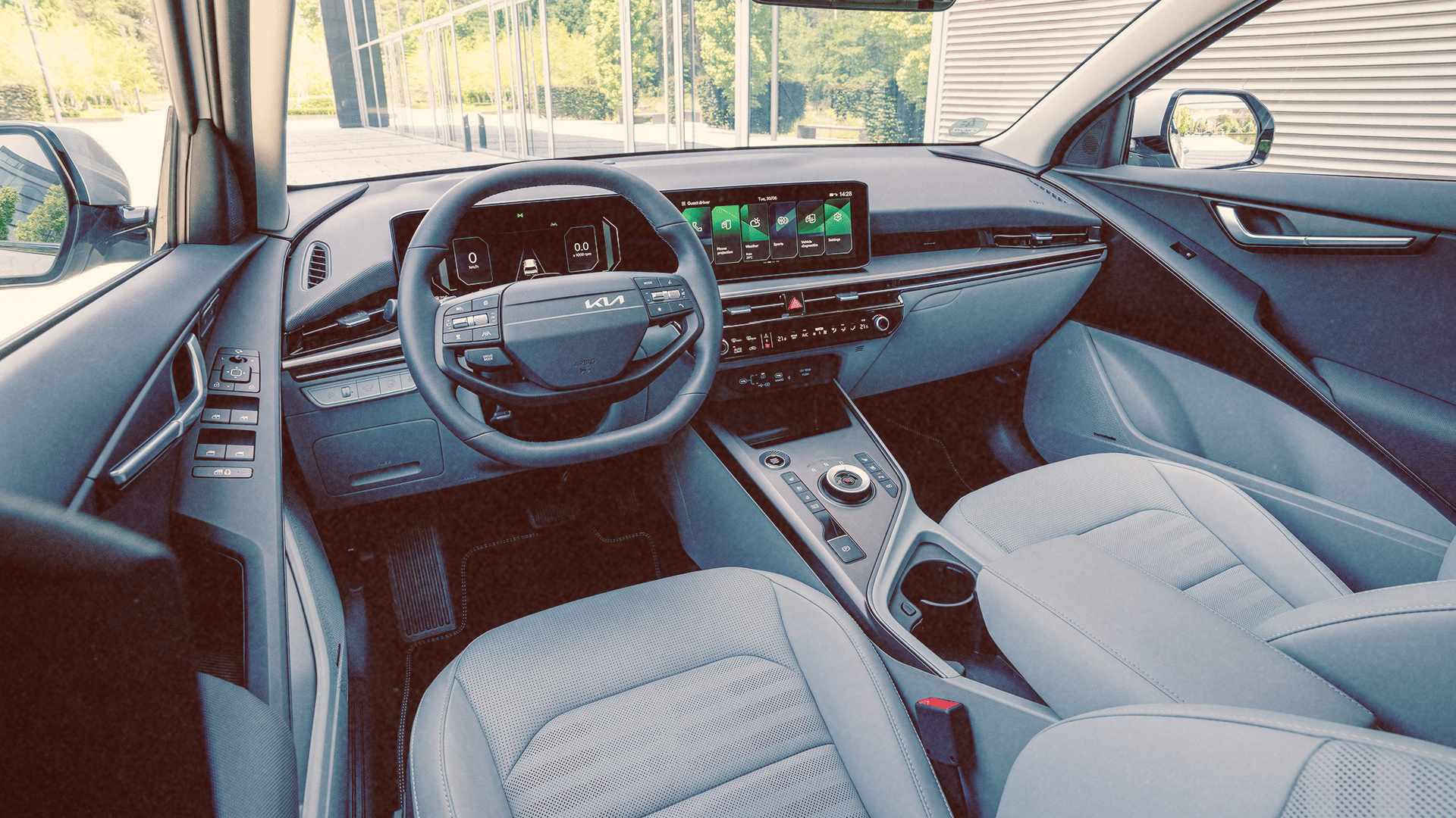 Modern interior of a Kia Niro car featuring a digital dashboard, touchscreen, and gray seats.