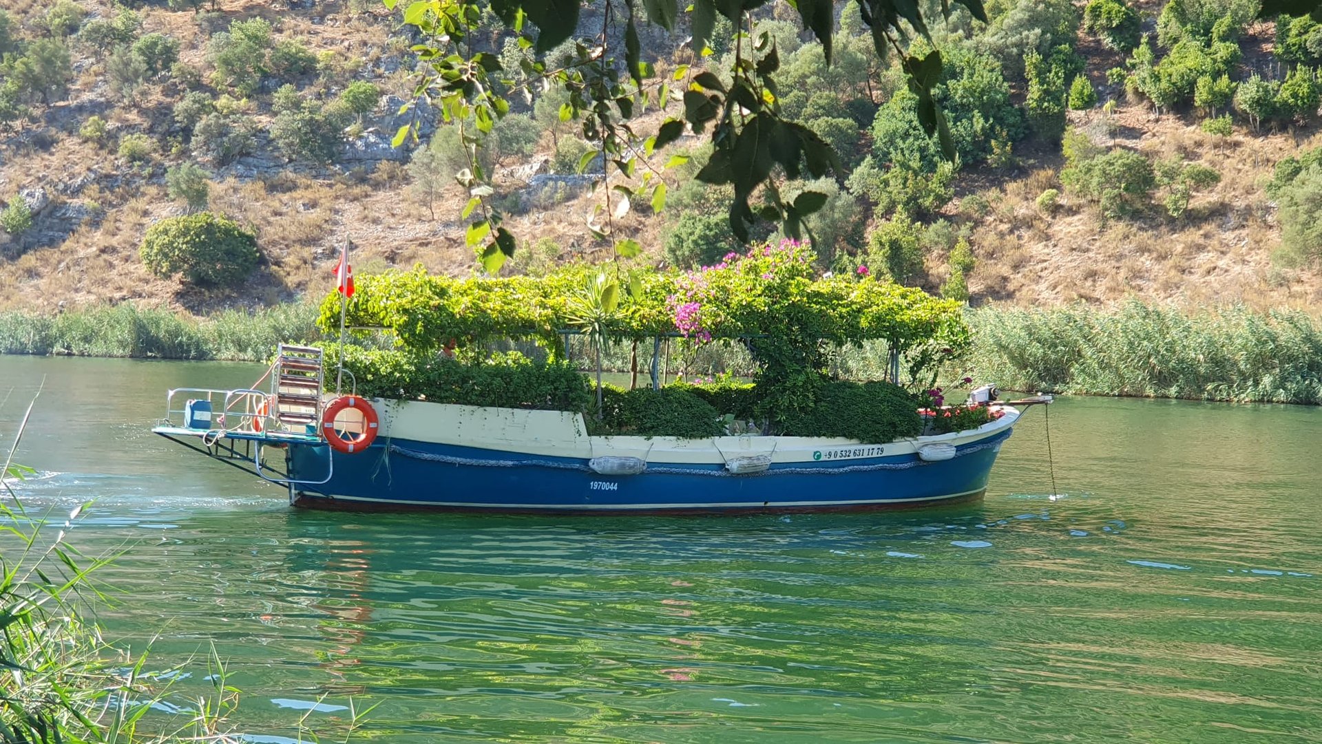 a boat covered with flowers in Dalyan River, one of the best places to visit in Dalyan