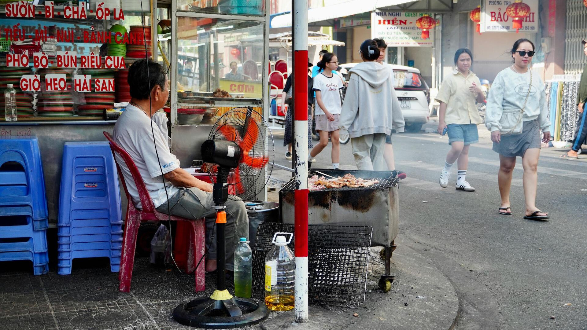 Local street food vendor cooking over charcoal in Vietnam