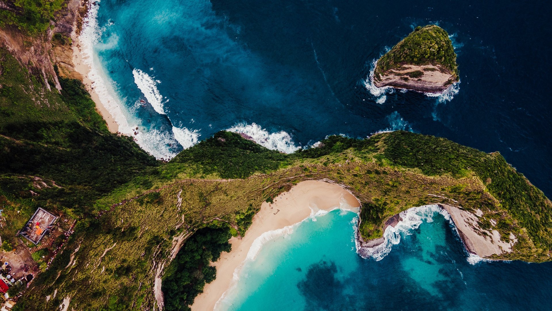 a view of a kelinking beach with a couple of people standing on the beach