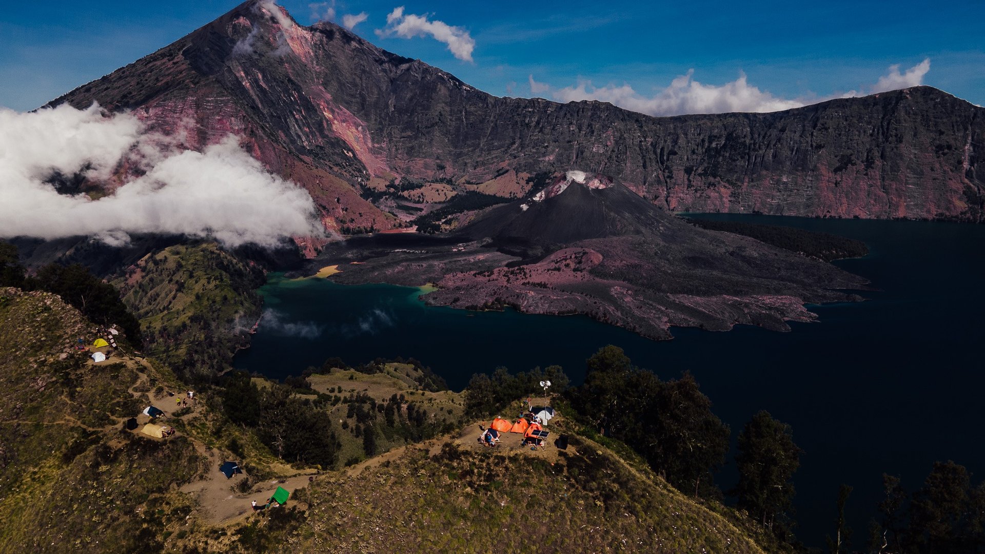 a group of people standing on a mountain top named Rinjani