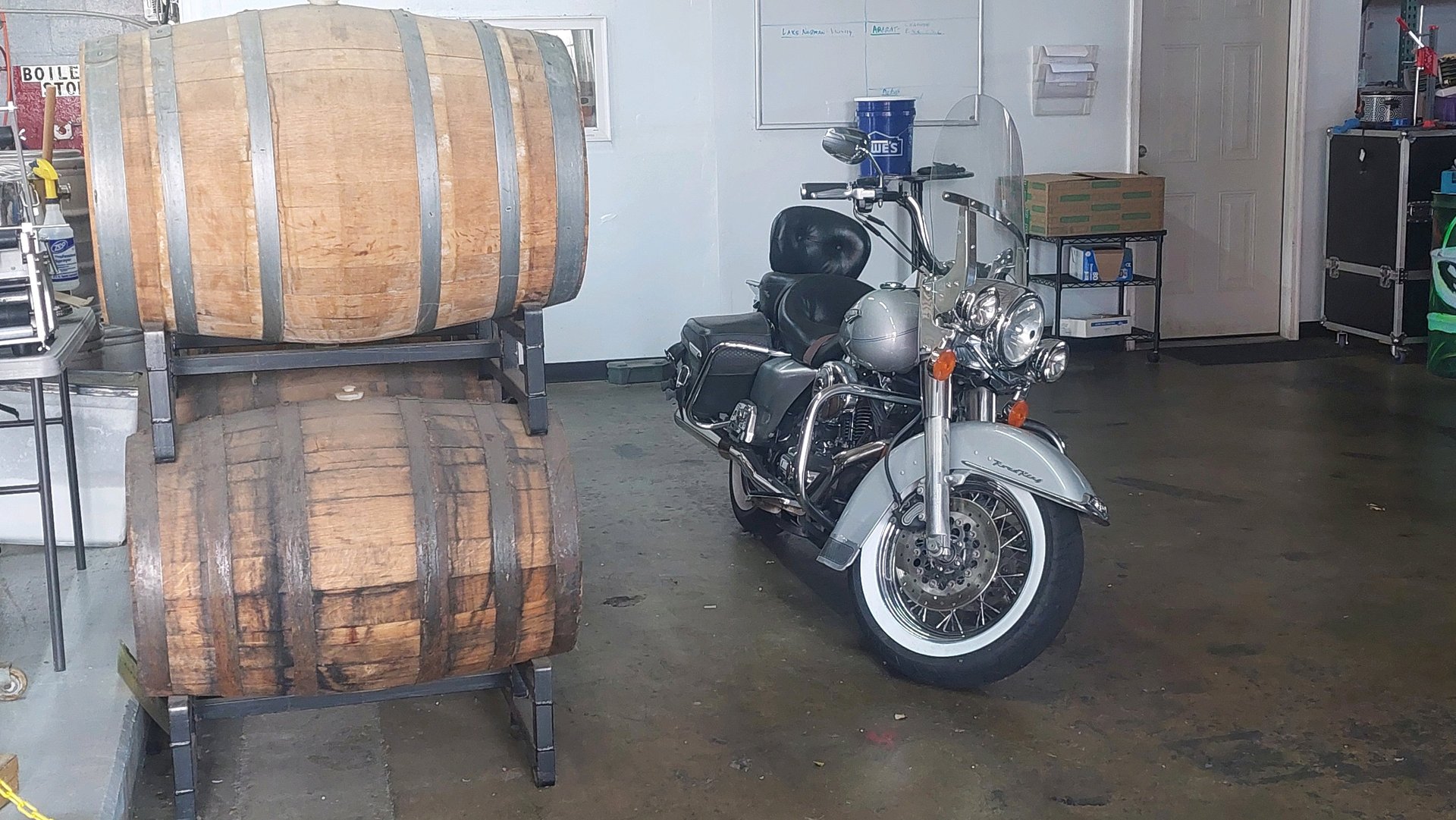 a motorcycle parked in a brewery with a barrel of beer