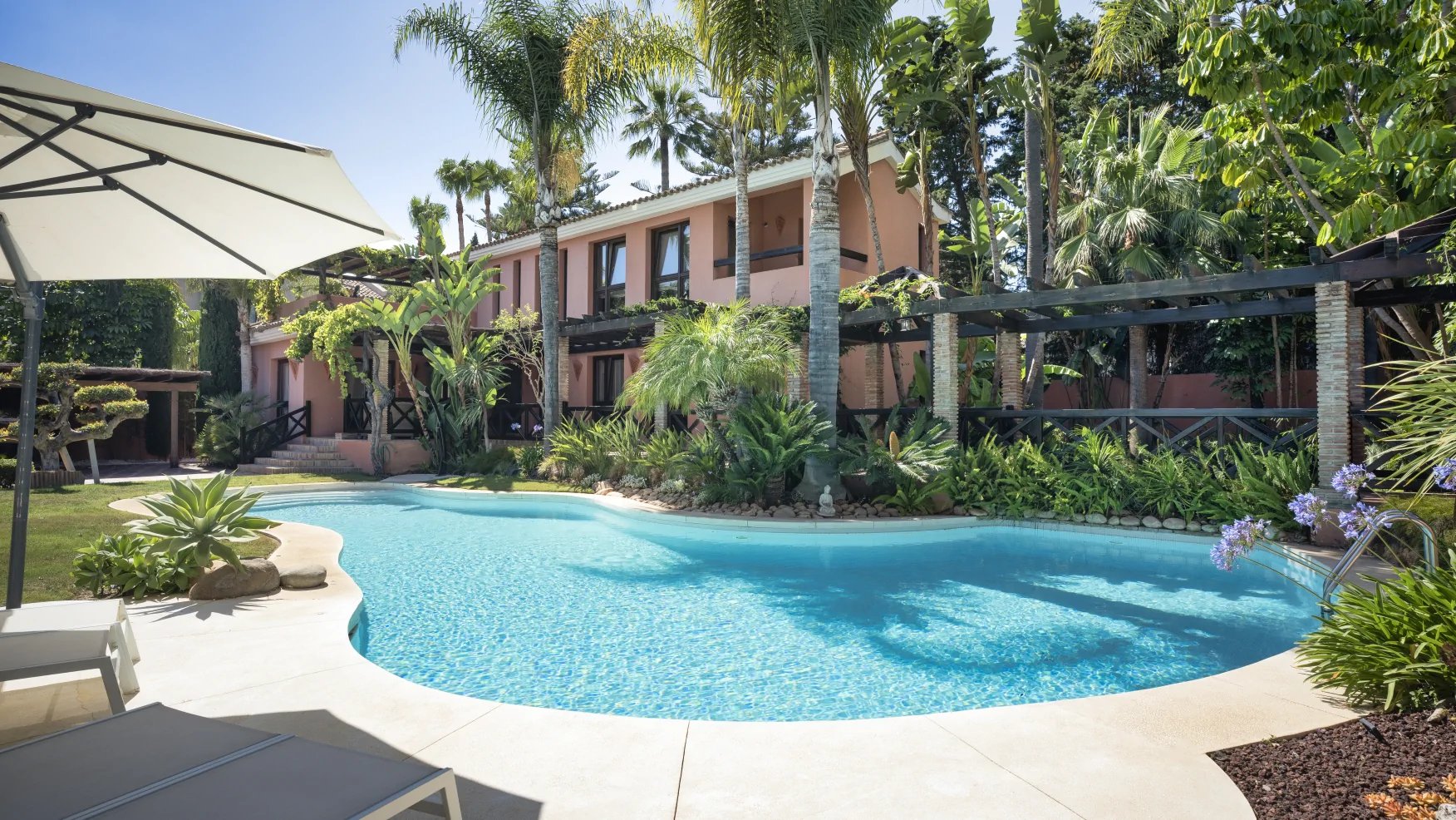 Saltwater swimming pool surrounded by tropical gardens at a private Marbella villa