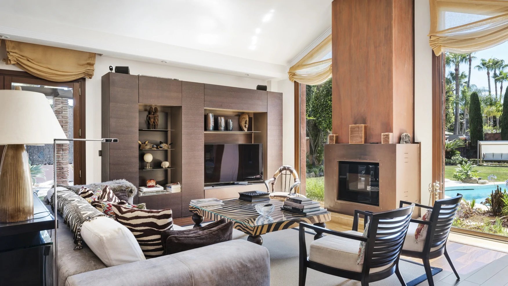 Elegant living room with fireplace overlooking the gardens of a luxury Marbella villa