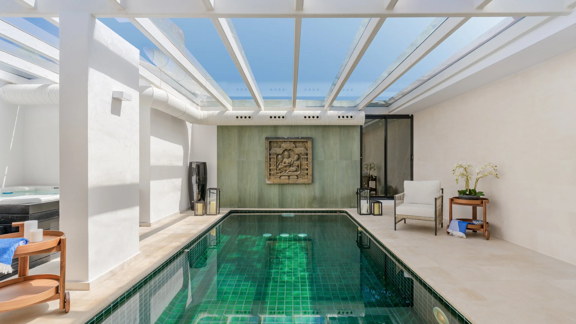 Indoor pool with glass ceiling and lounge area