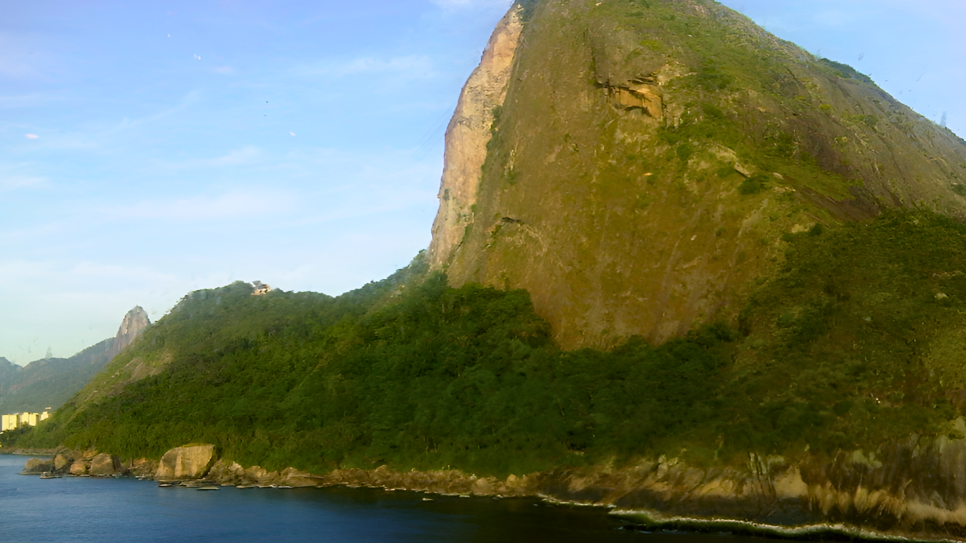 Navio de cruzeiro chegando ao Rio de Janeiro com o Pão de Açúcar ao fundo.