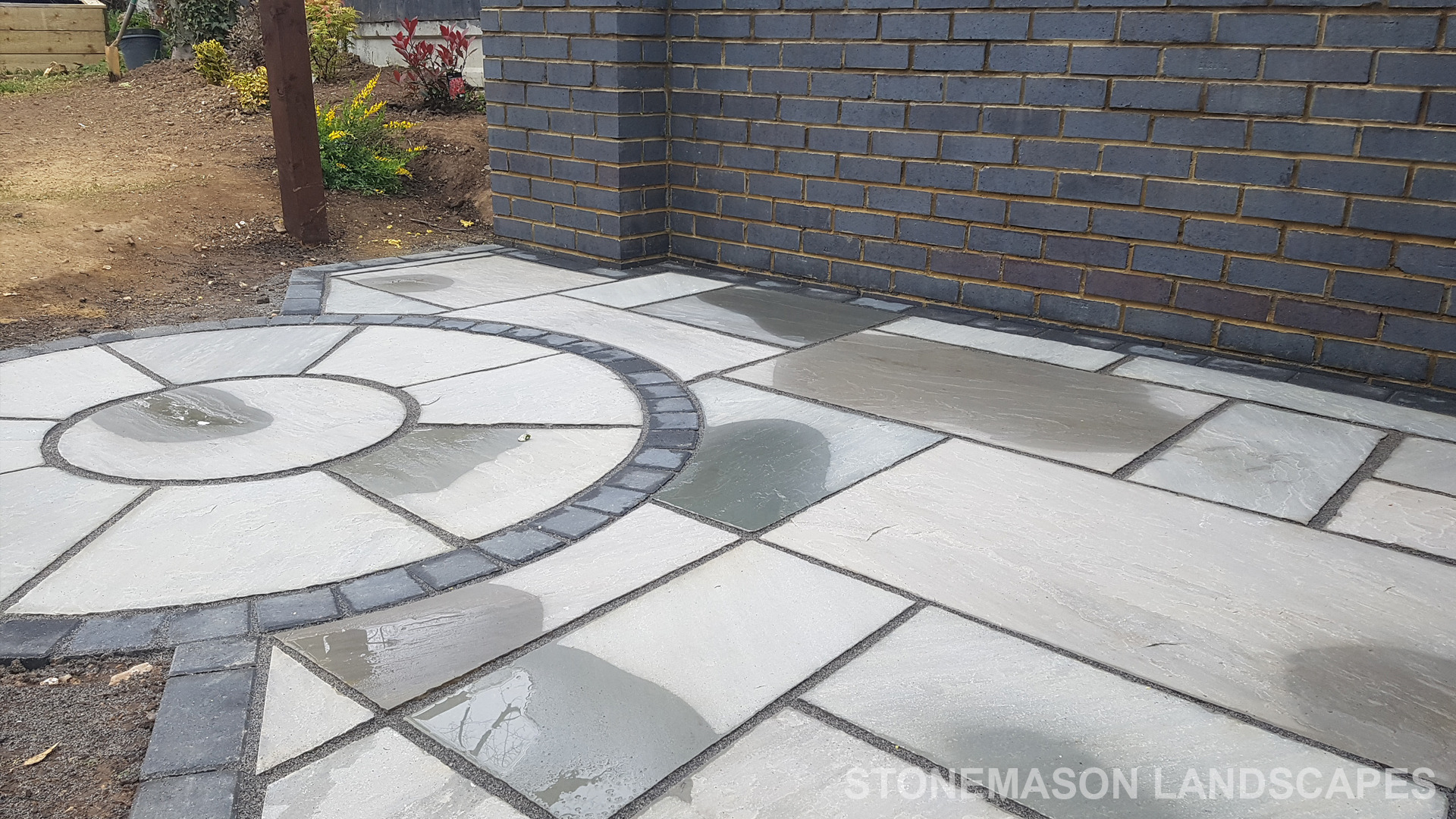 Grey sandstone circle paving slabs with charcoal edging