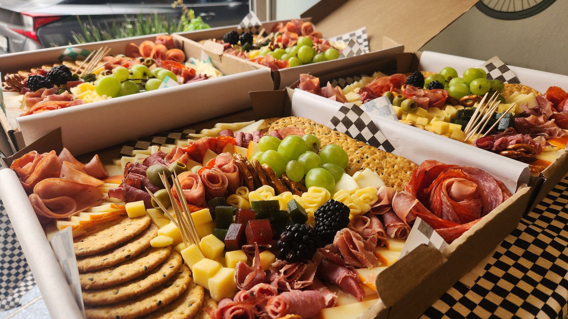 a variety of food, cheese, fruit and crackers in boxes
