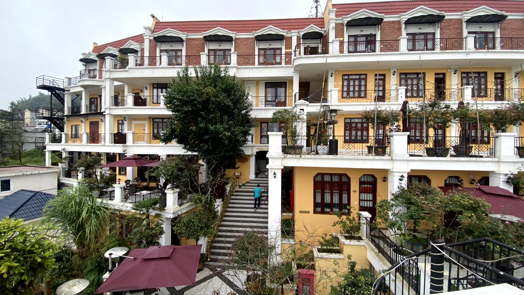 a building with a staircase leading to a building with a red roof