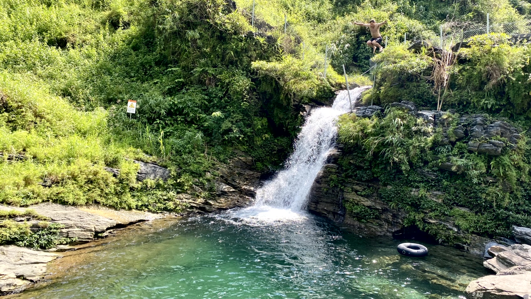 a man is standing in front of a waterfall
