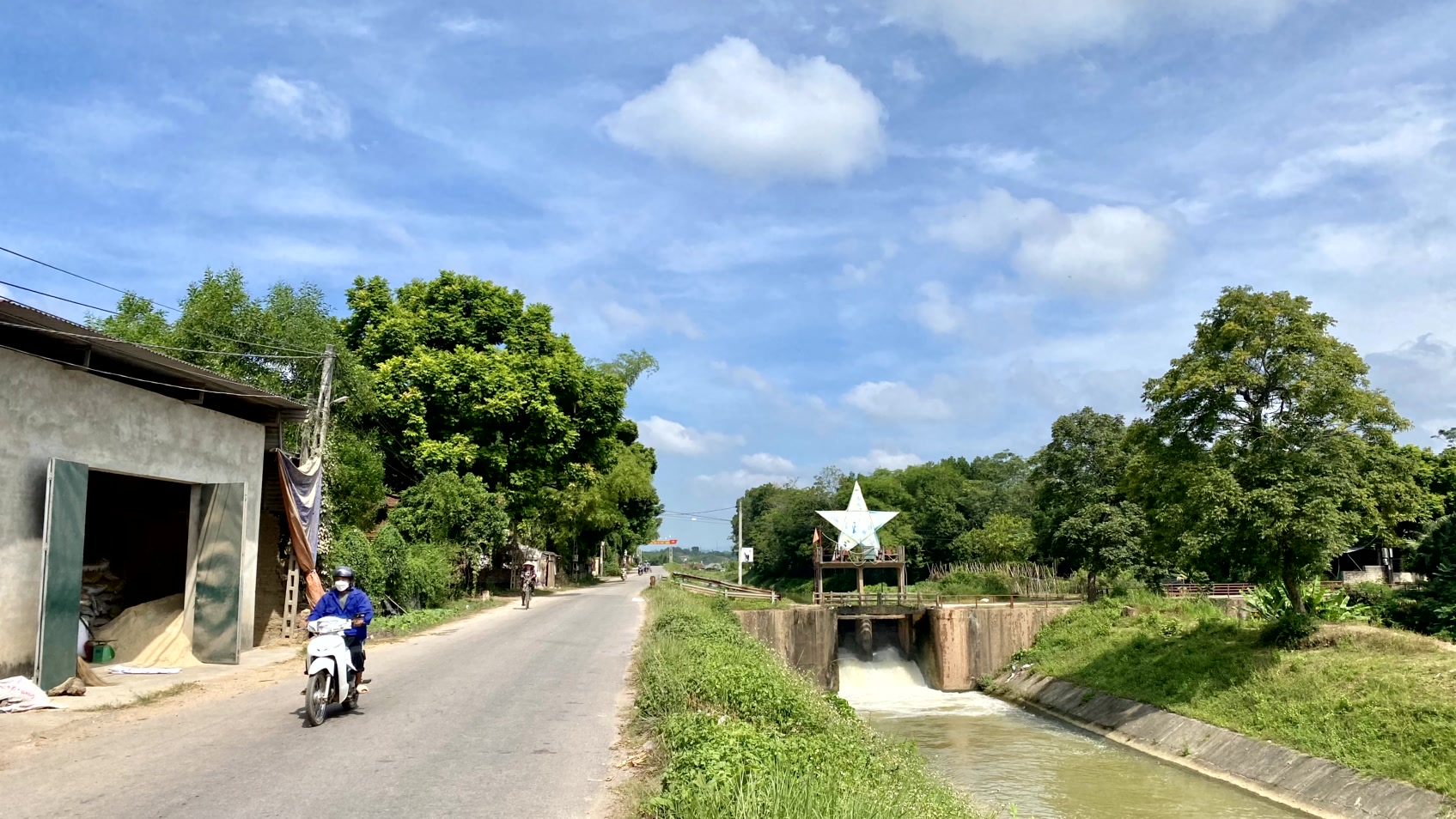 a person riding a motorcycle down a narrow road