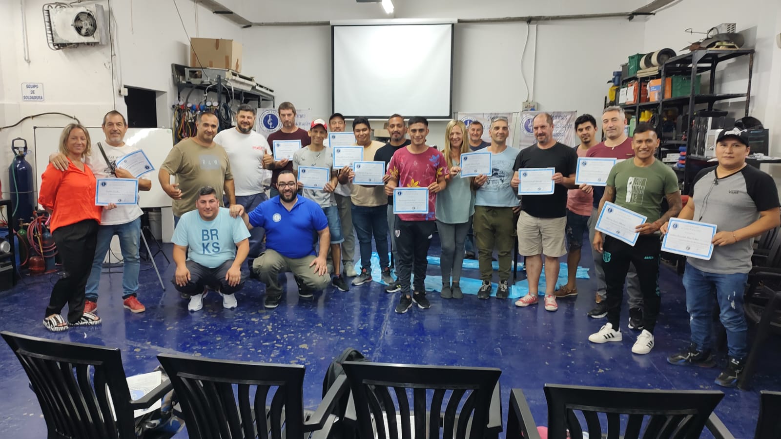 a group of people standing around a table with certificates. , Entrega de Certificados en ICL