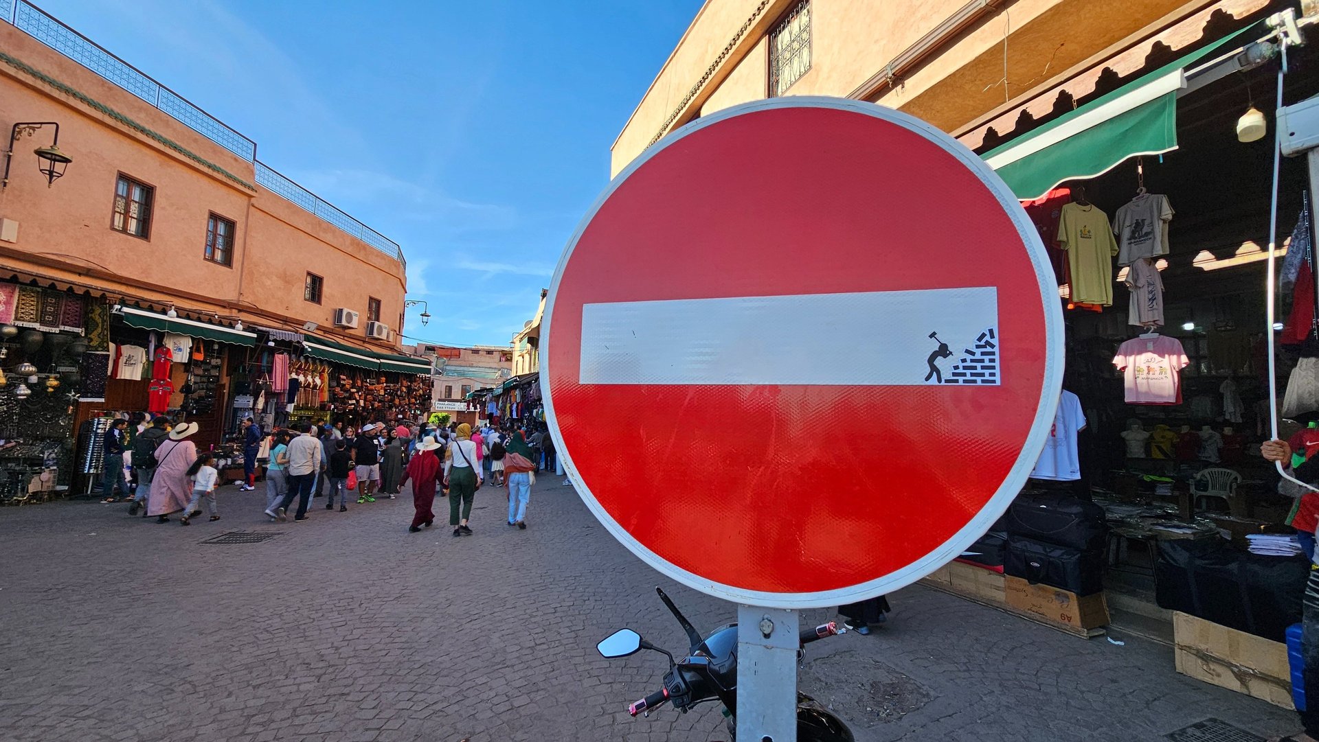 Détournement de panneaux de signalisation représentant un homme détruisant un mur sur sens interdit 