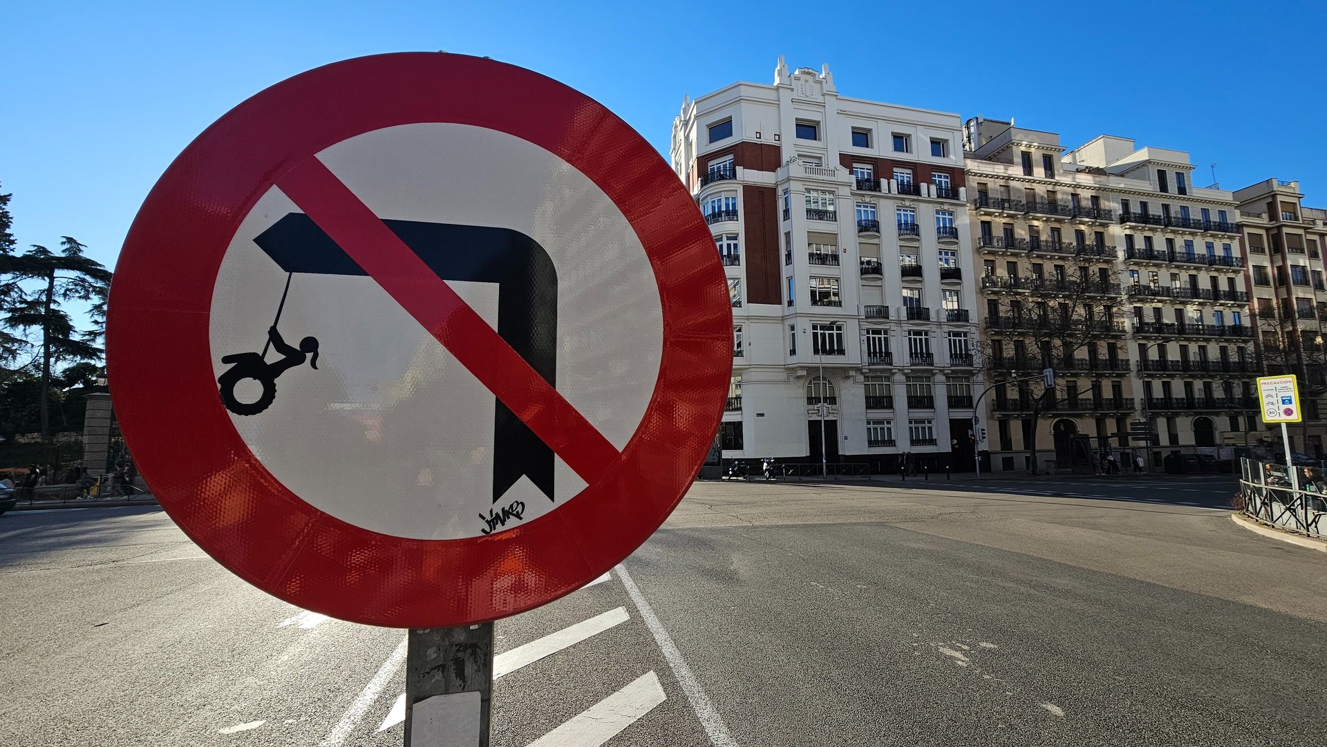 Street art sur panneau de signalisation représentant un fille sur une balançoire