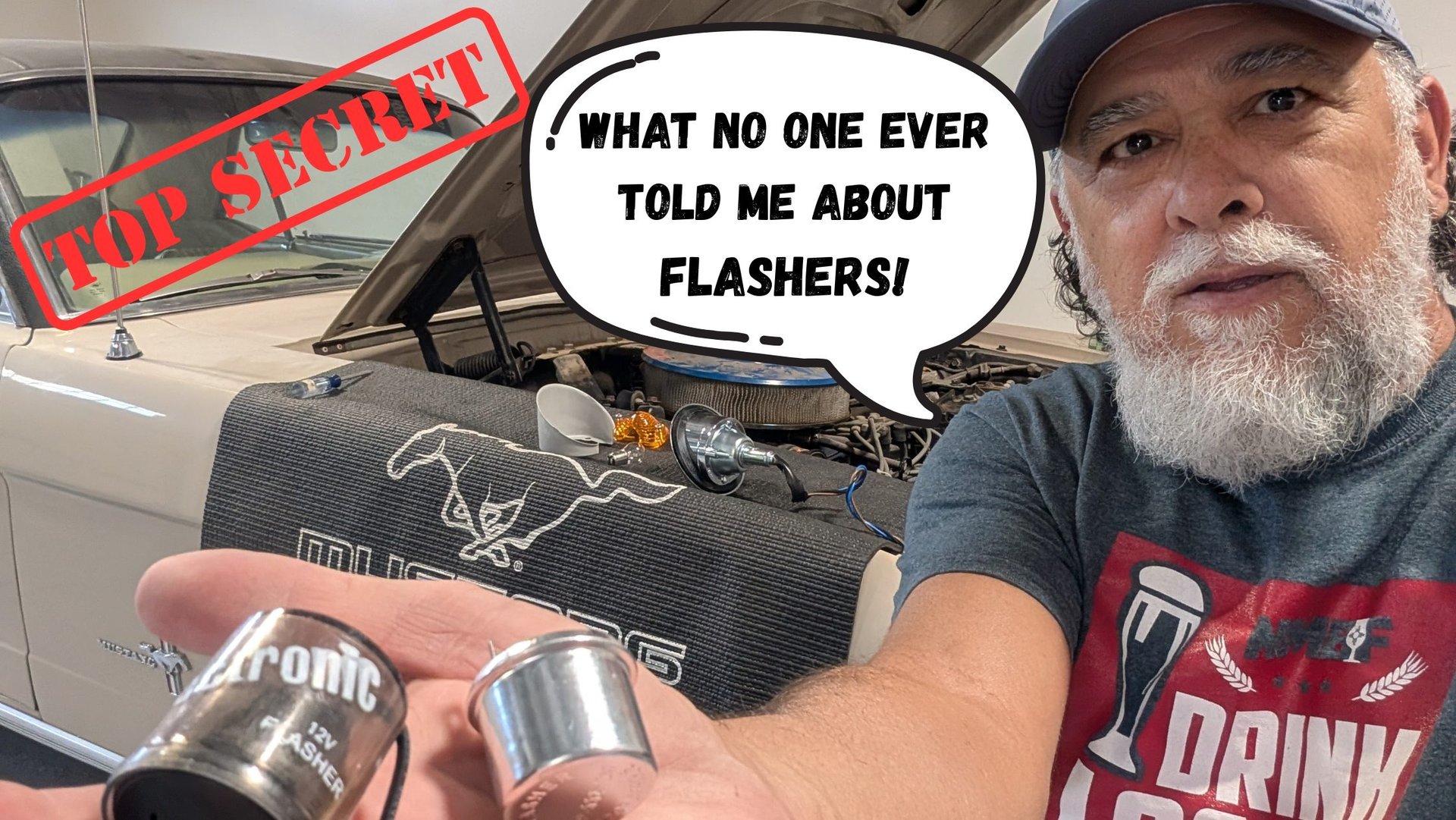 A mechanic holding a 12V car flasher relay in front of a classic Ford Mustang engine bay.