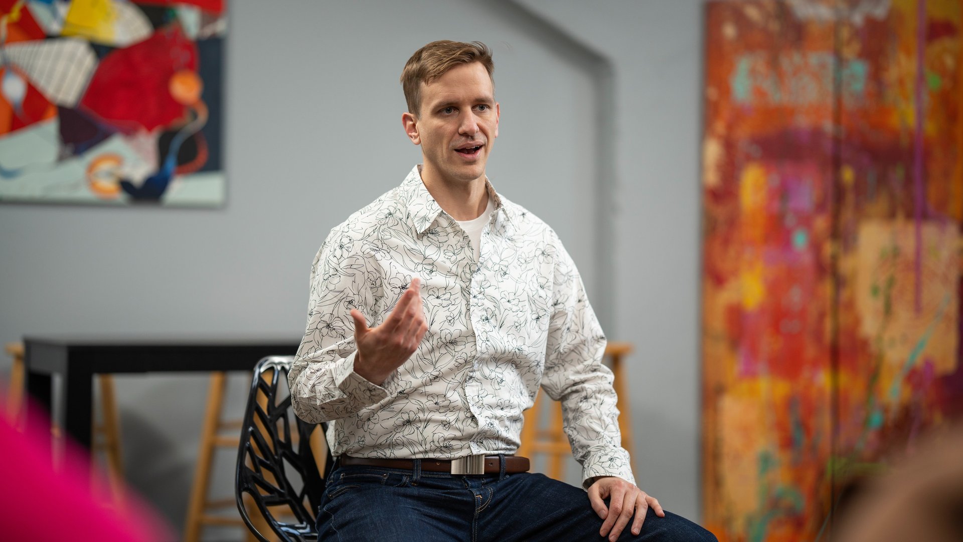 Remy sits gesturing during a small group talk