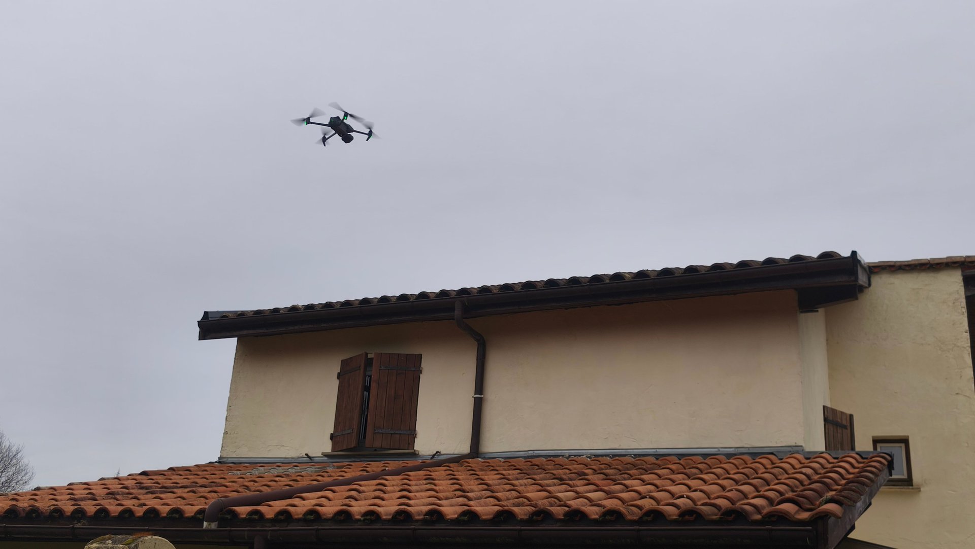 drone de surveillance survolant un toit de maison avec des tuiles en terre cuite pour une inspection