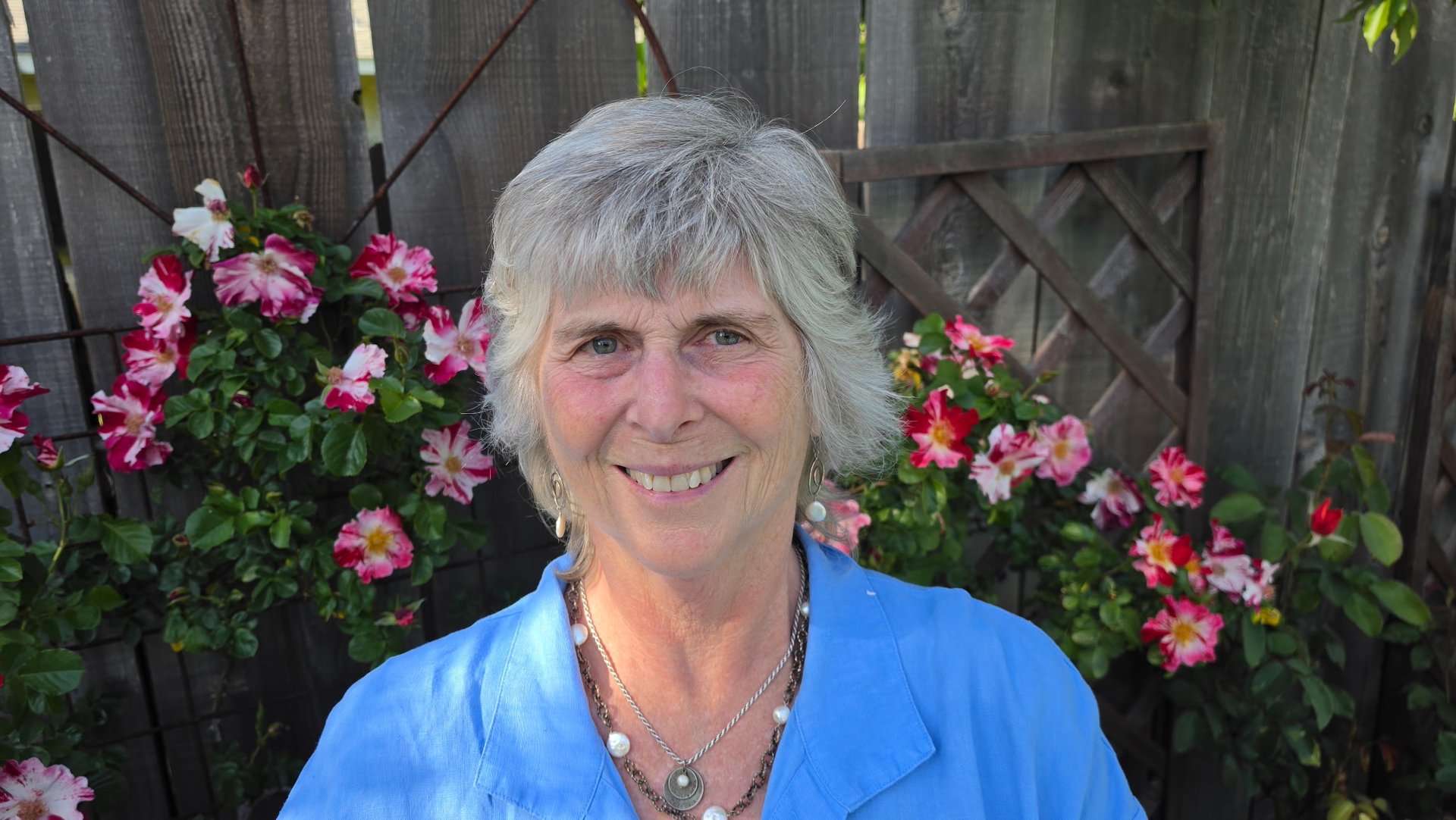 Portrait of Teresa Wood-Hansen with beautiful pink flowers in the background