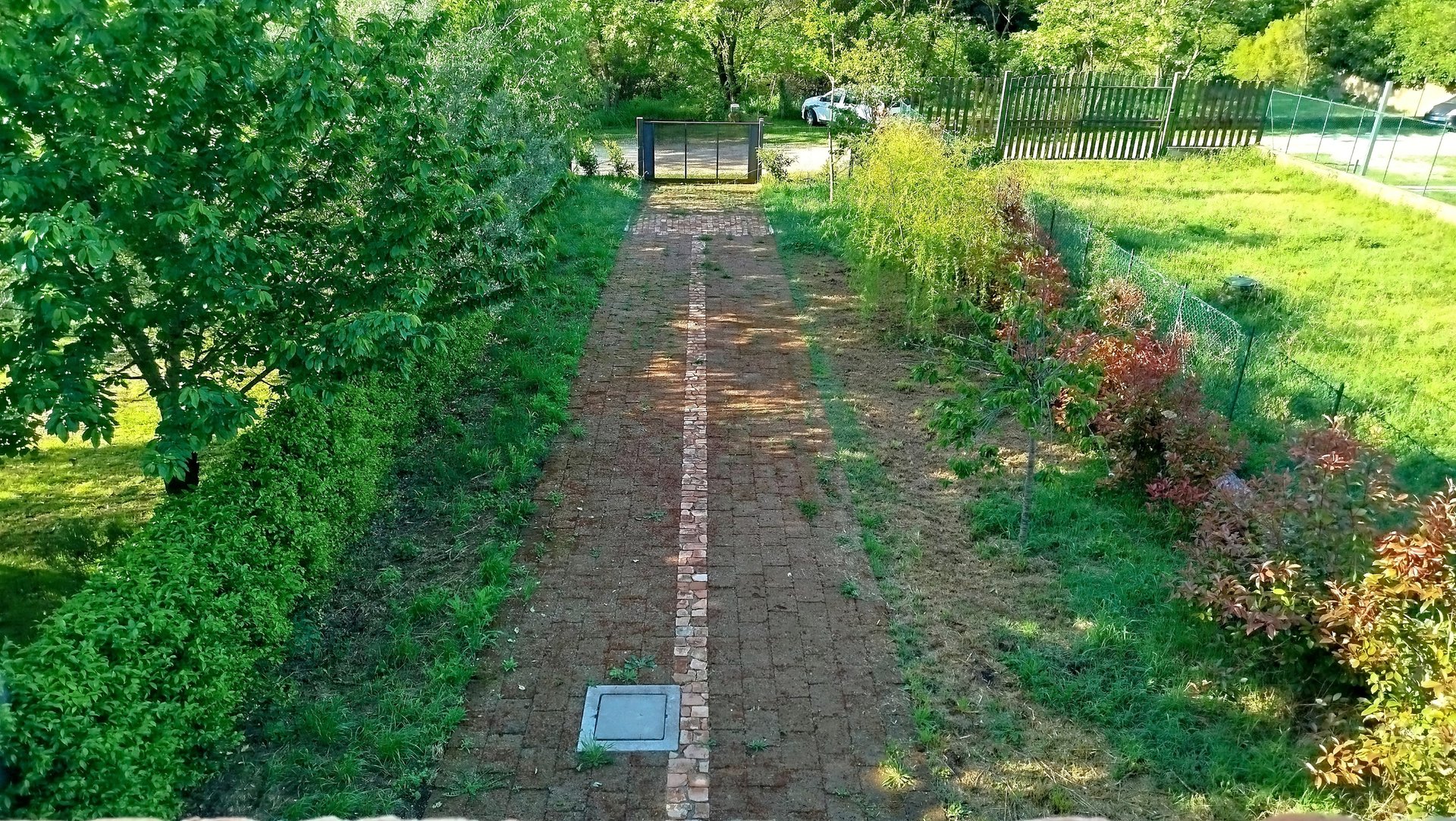 Giardino privato in vendita con vialetto pavimentato e accesso carrabile.