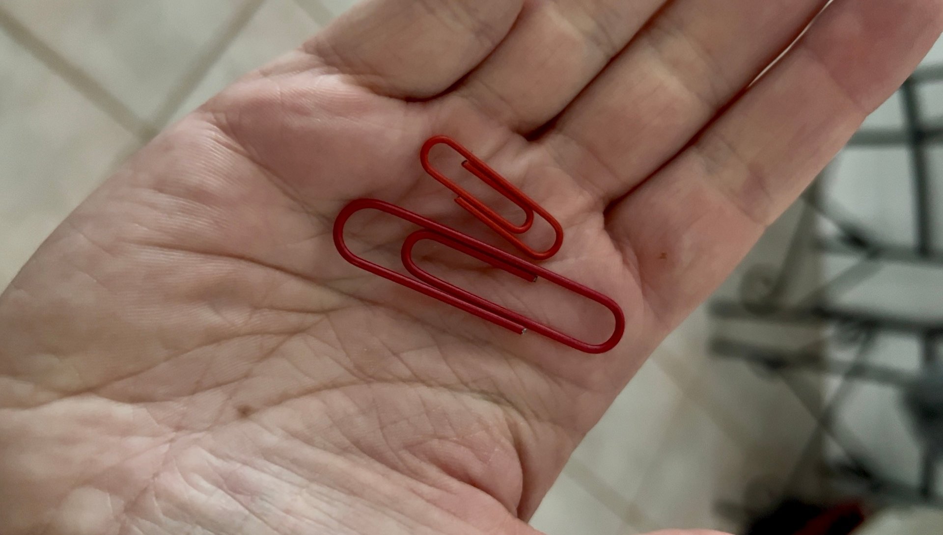 two red paper clips held in hand