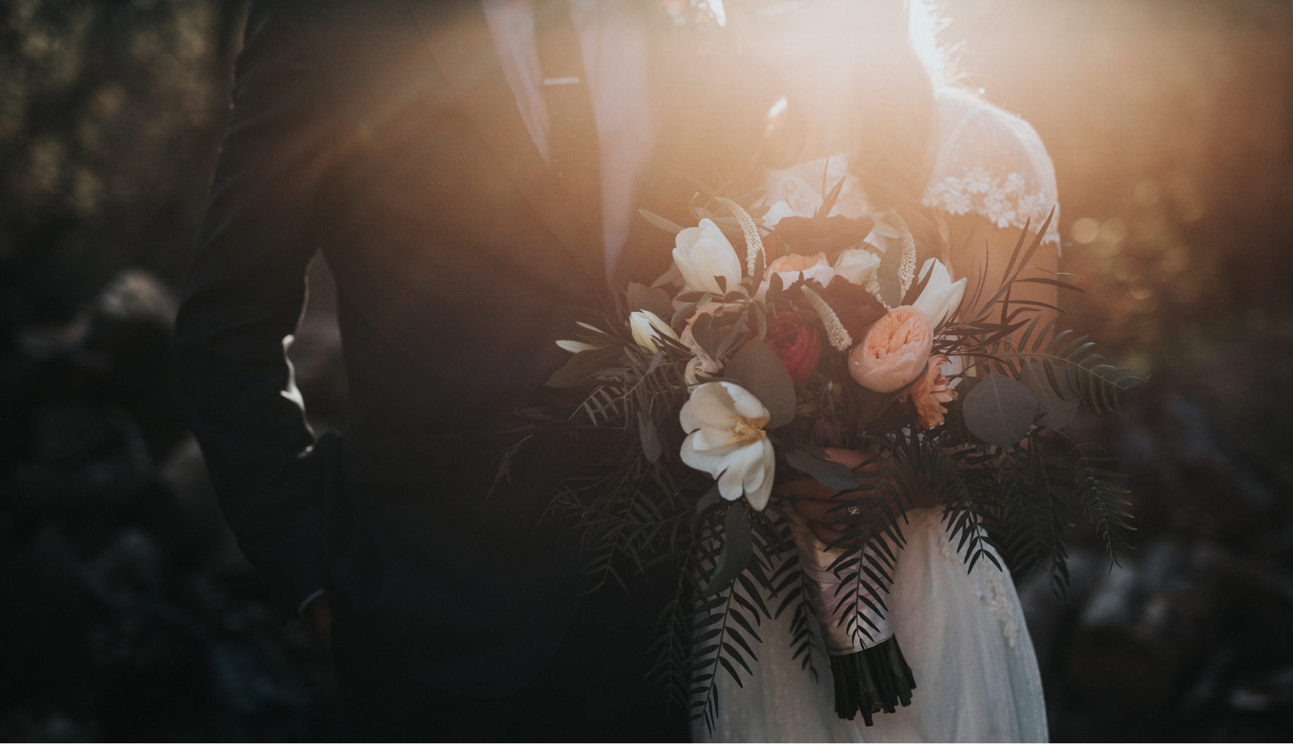 a bride and groom holding a bouquet of flowers