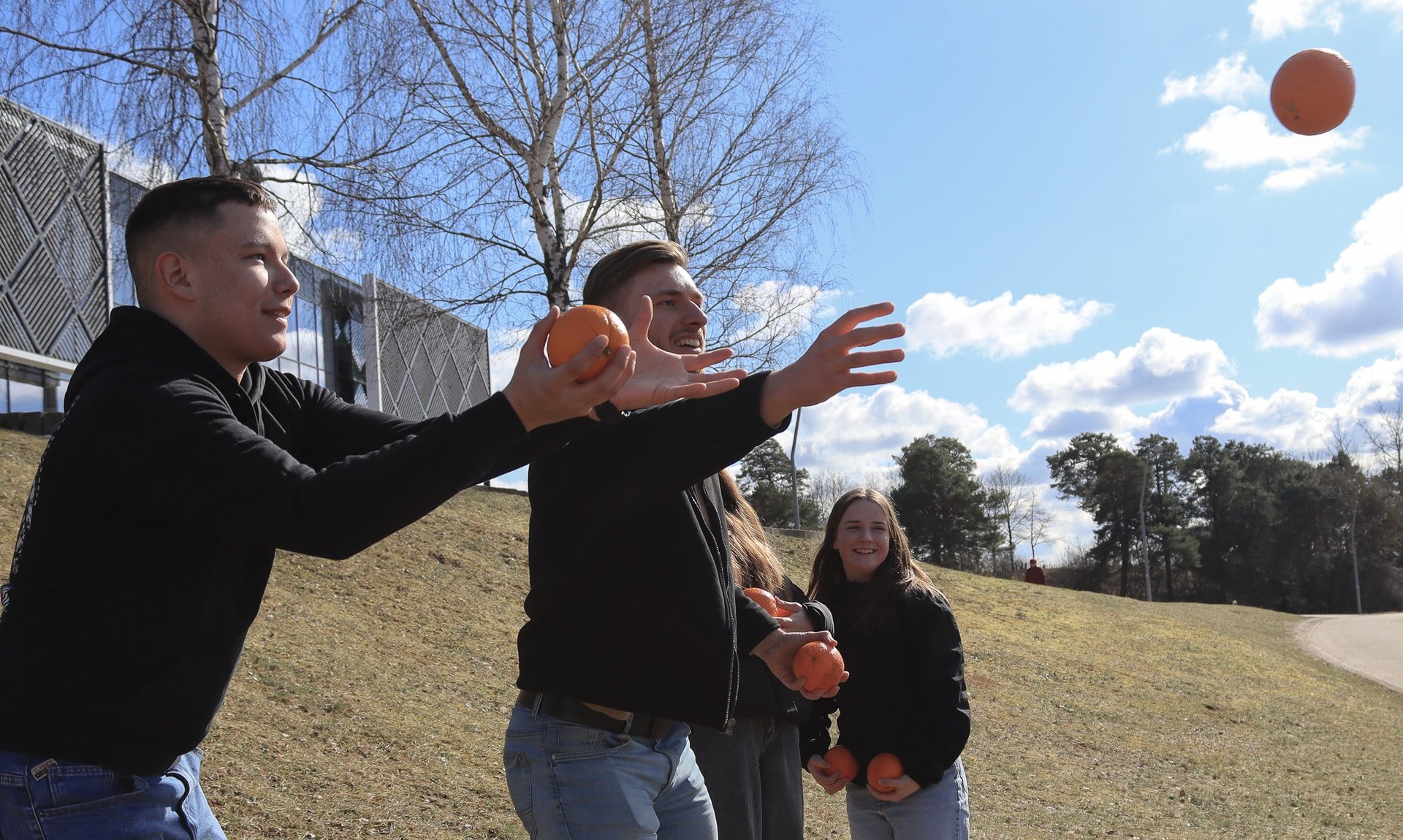 jauni vaikinai gaudo apelsinus