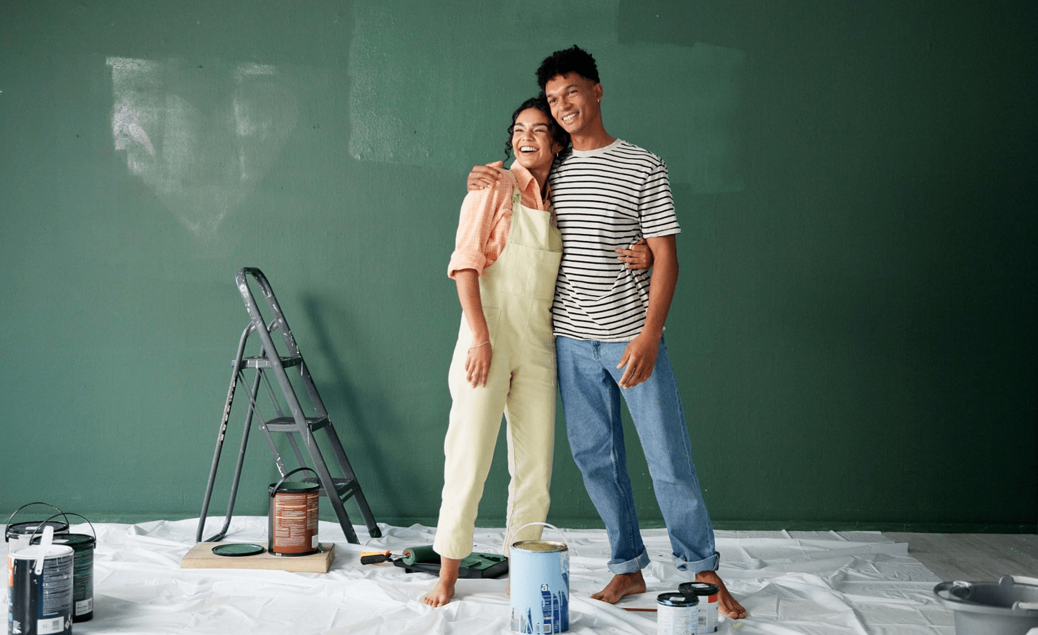 a man and woman standing in front of a green wall