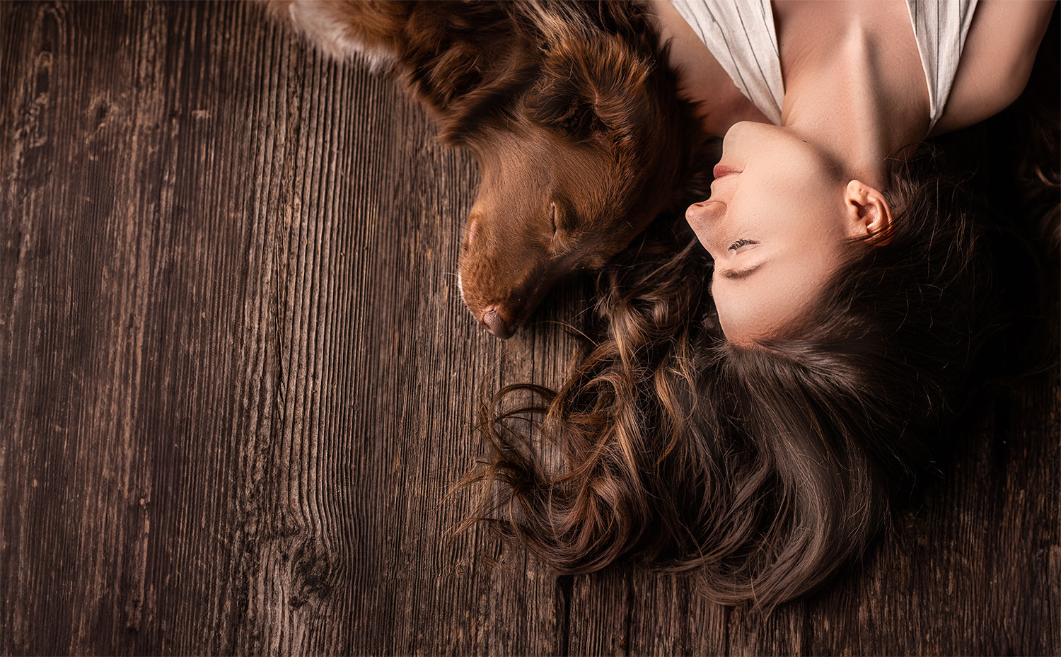 Frau liegt mit ihrem Hund bei Fine Art Fotoshooting in Niederösterreich, ruhige Mensch-Hund Verbindu