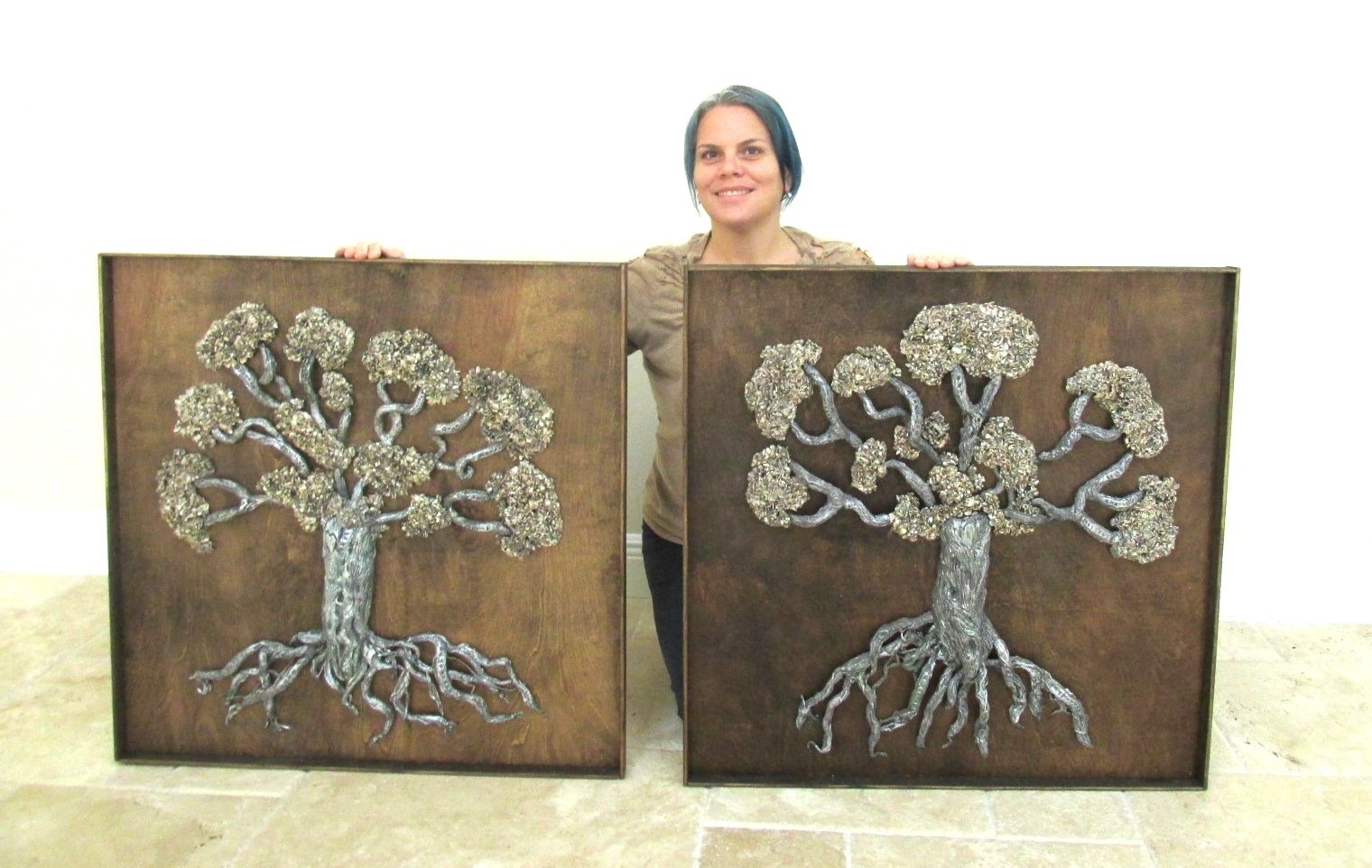 visual artist holding sculpture of trees