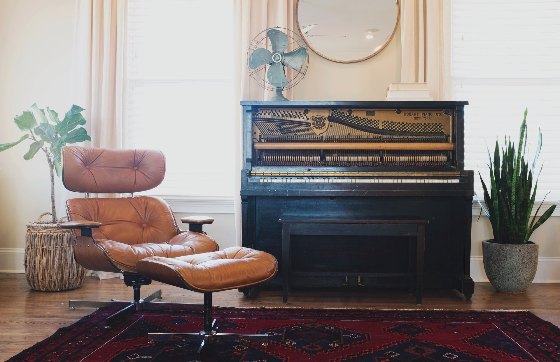 relaxing leather chair with footstool. Black piano in background with retro fan on top