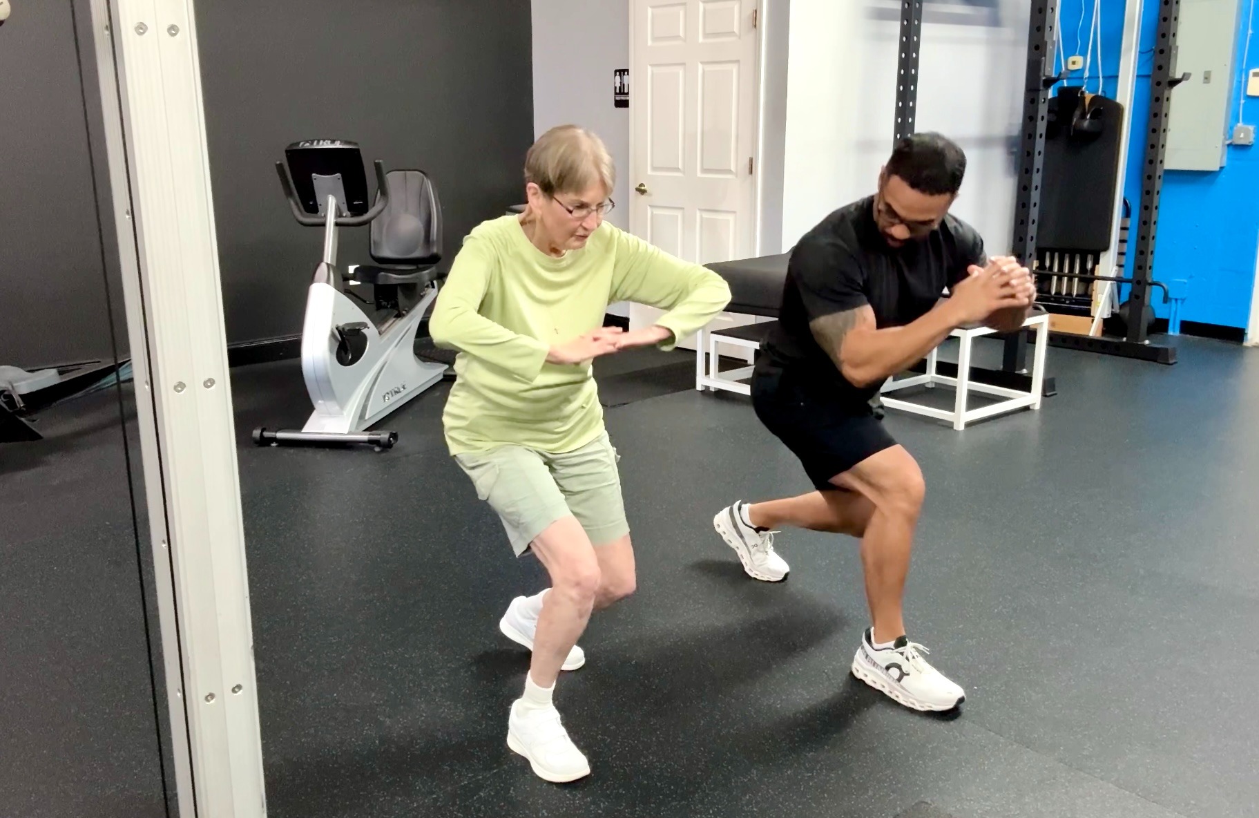 fitness trainer with elderly woman exercising