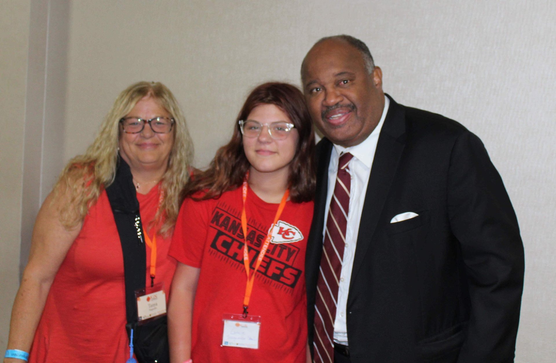 Dominic Carter at the Missouri Kinship Conference speaking with a teenager and her aunt who is raising her — highlighting fam