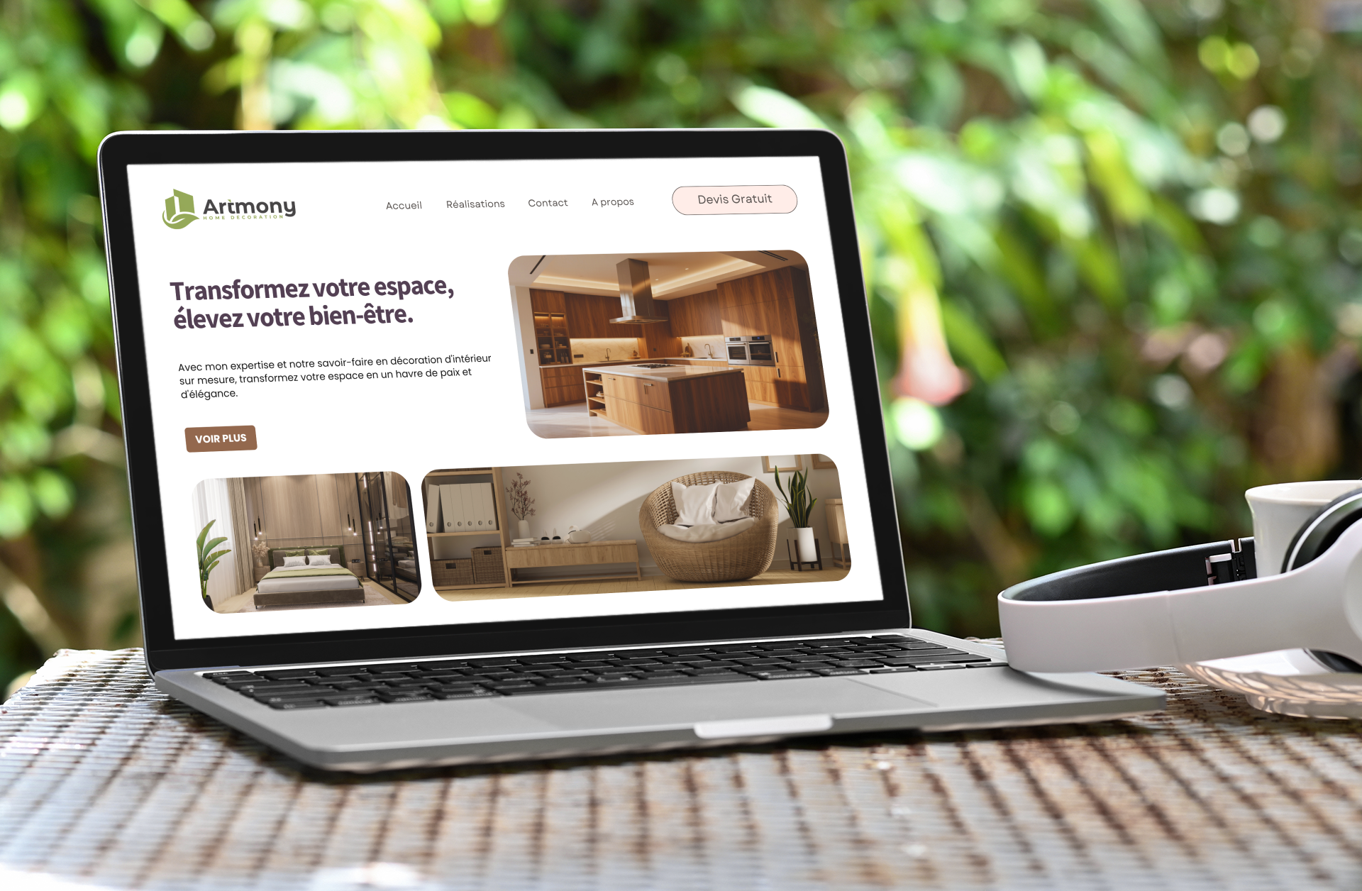 Ordinateur portable affichant le site web et le logo d'un designer d'intérieur avec des images