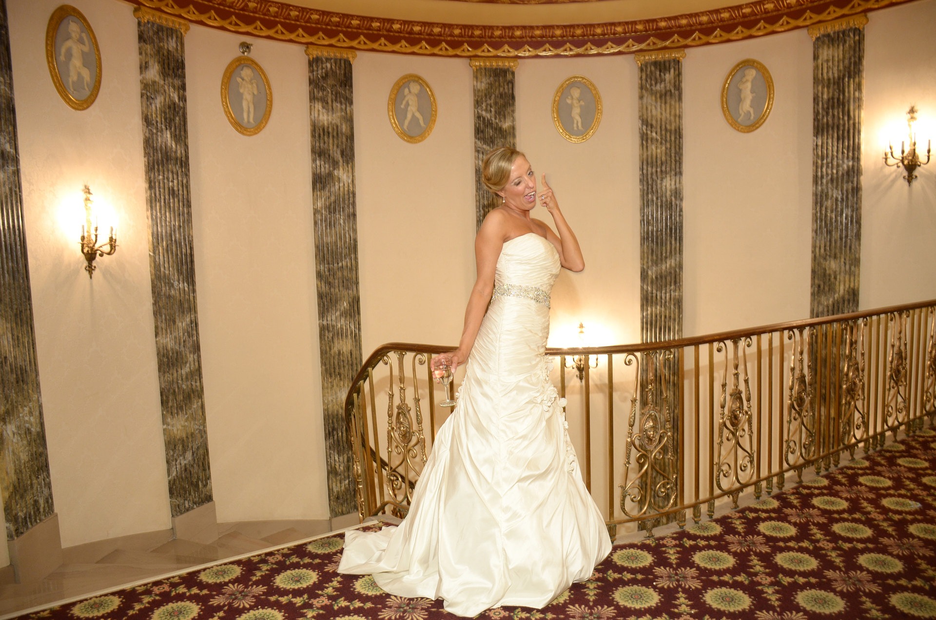 a woman in a white dress posing in the hotel lobby
