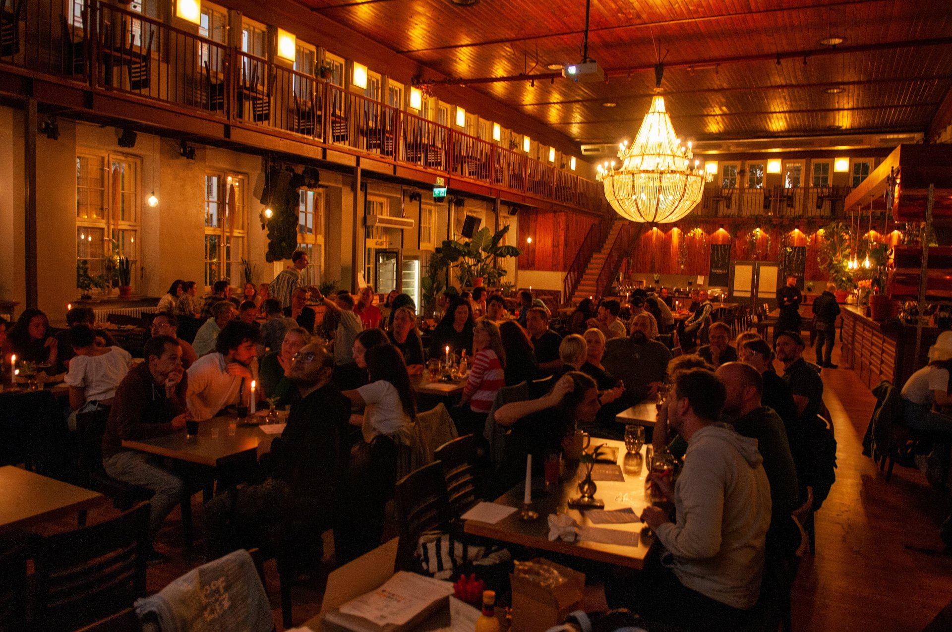 Menschen sitzen in Gruppen beim Quiz in Berlin