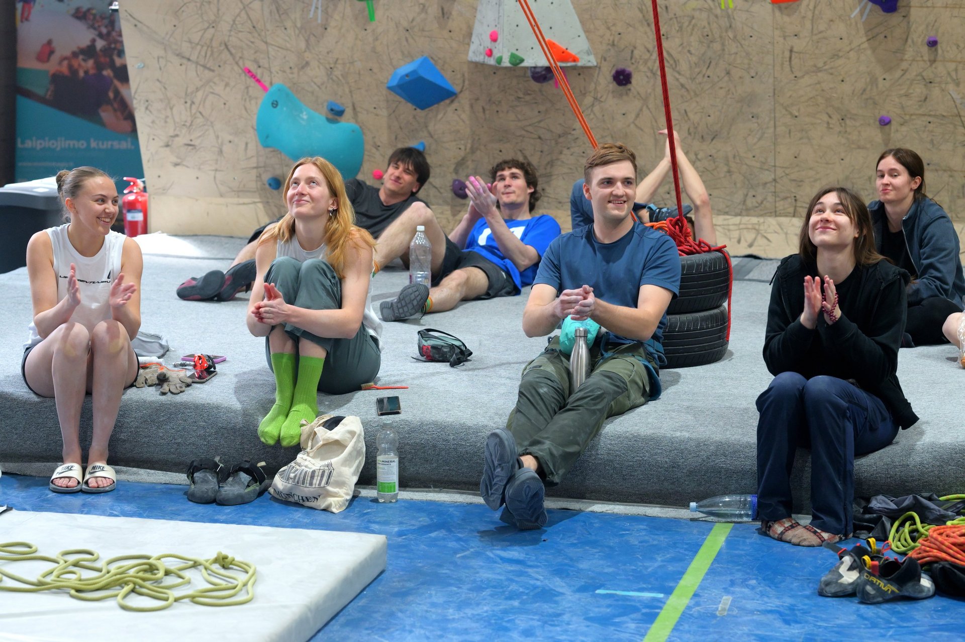 a group of people sitting on a bouldering mat