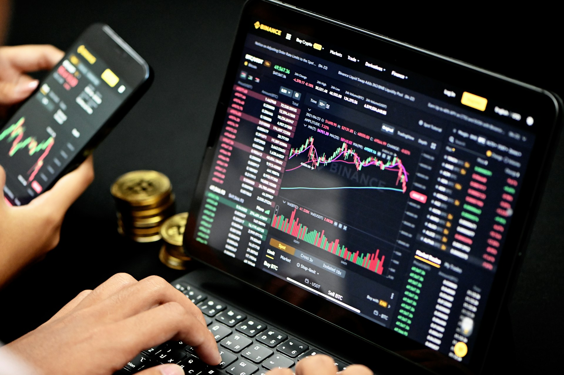 person trading on their computer with bitcoin on the side