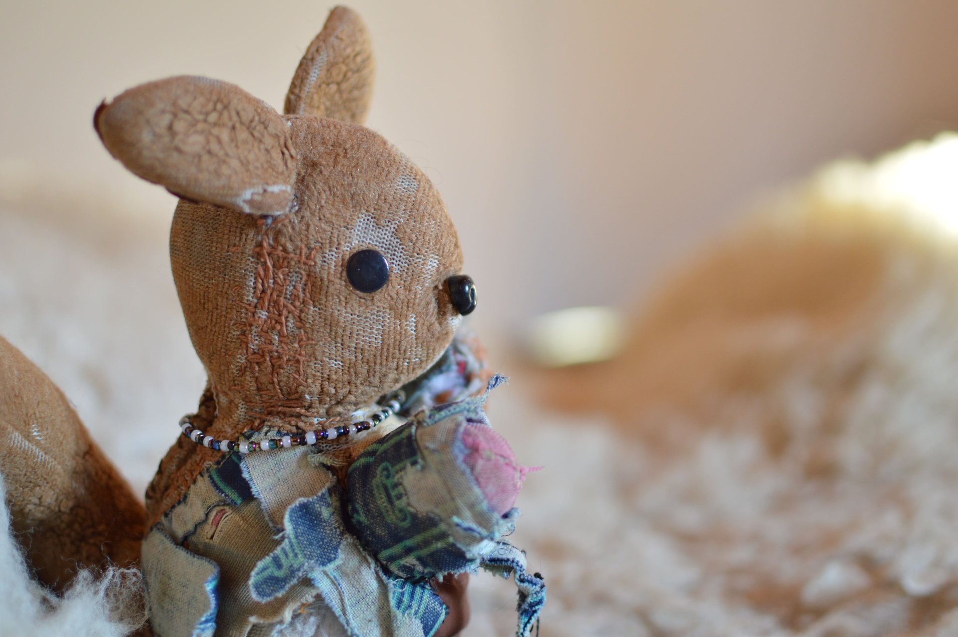 doudou ancien usé, peluche patinée avec signes d’usure et regard face caméra