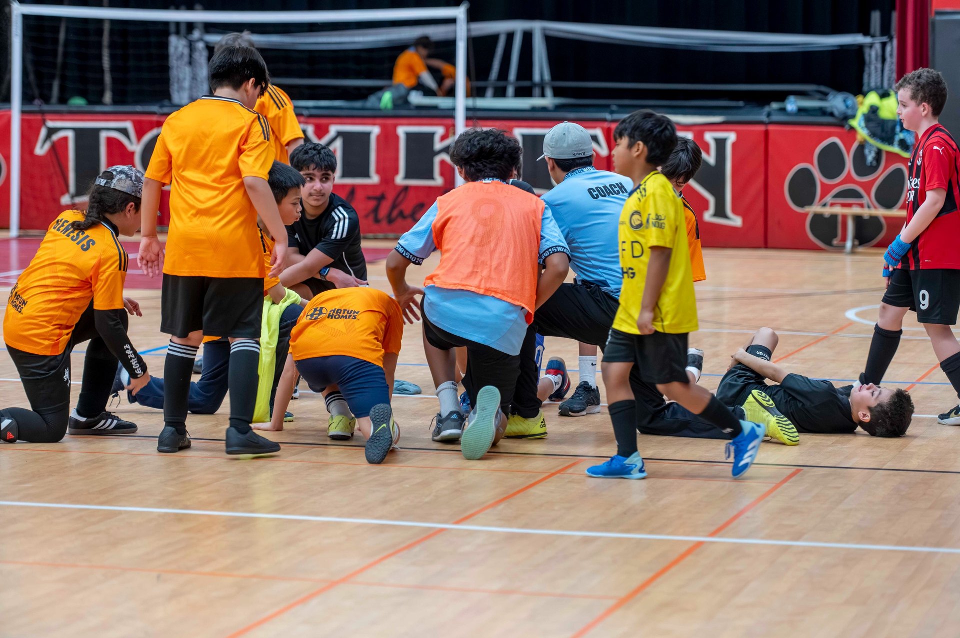 MVB F.C. huddle with their coach during recovery time after a youth soccer training session.