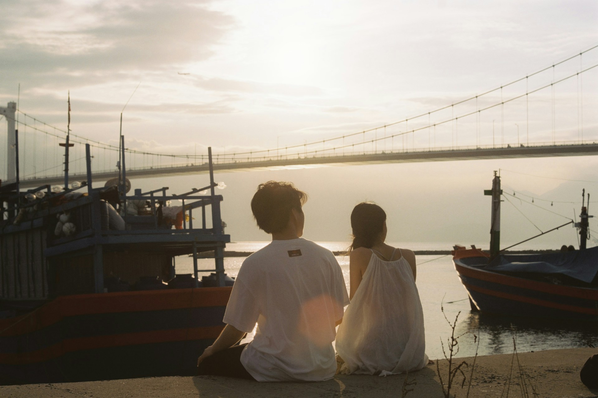 Couple sitting by the Han River in Da Nang, Vietnam
