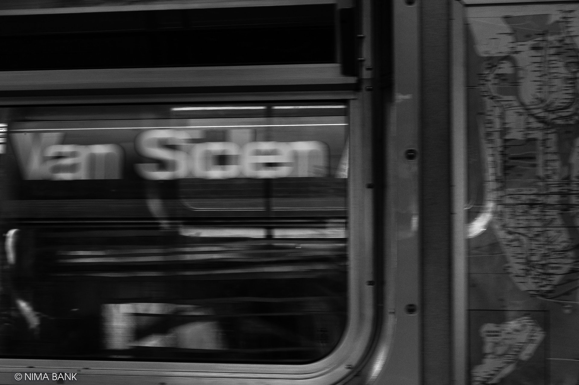 a blurred black and white image of the inside of a subway car while its whirring by the van siden