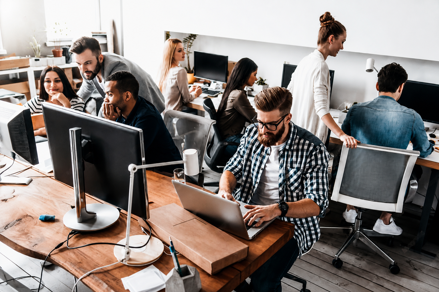 Software development team working on a secure creator platform in a modern office.