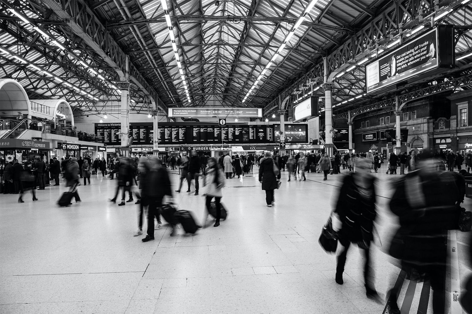 a group of people walking through a train station