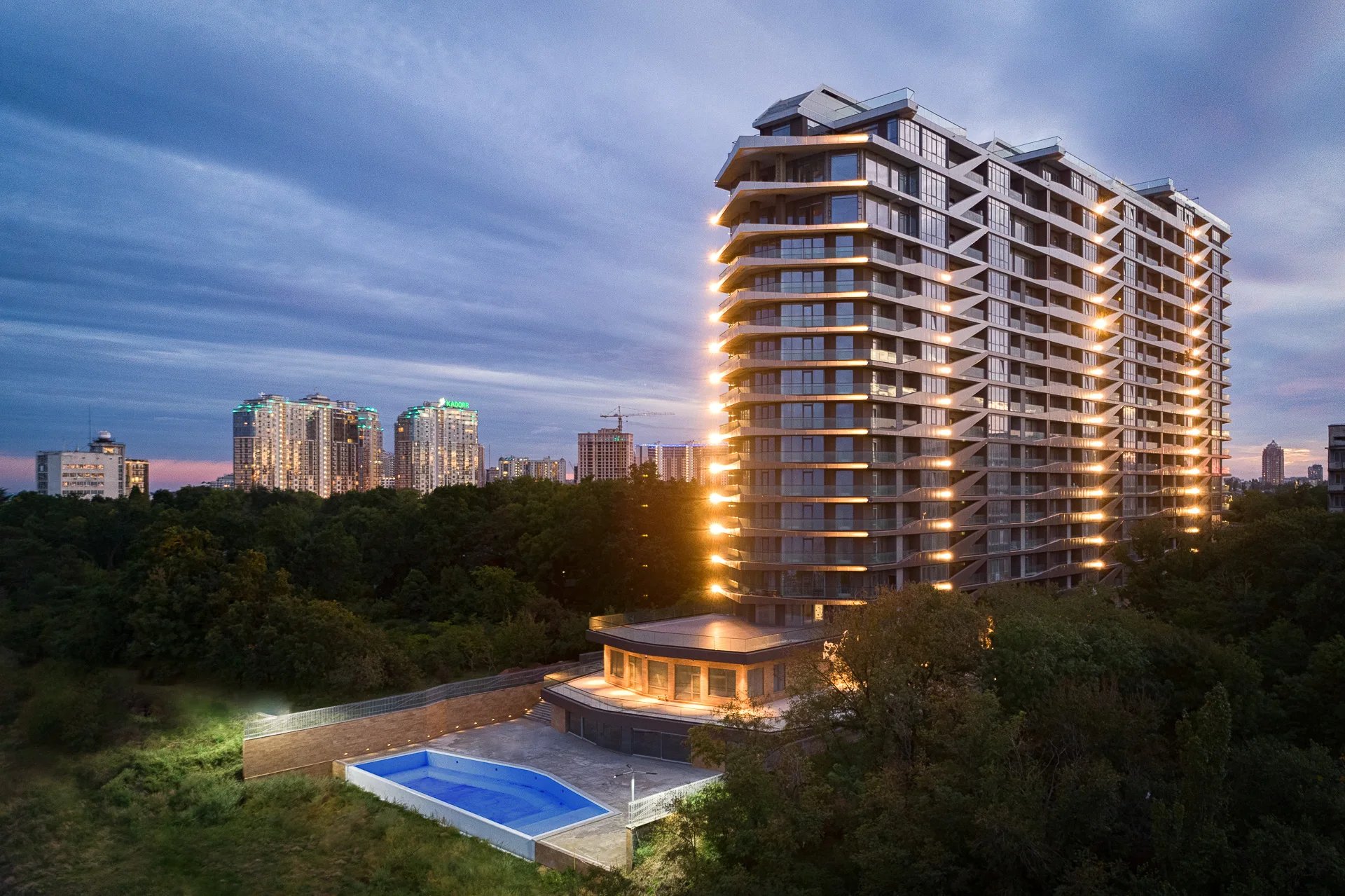 fotografia architektoniczna wielemieszzkzniowego gmachu po zachodzie słońca 