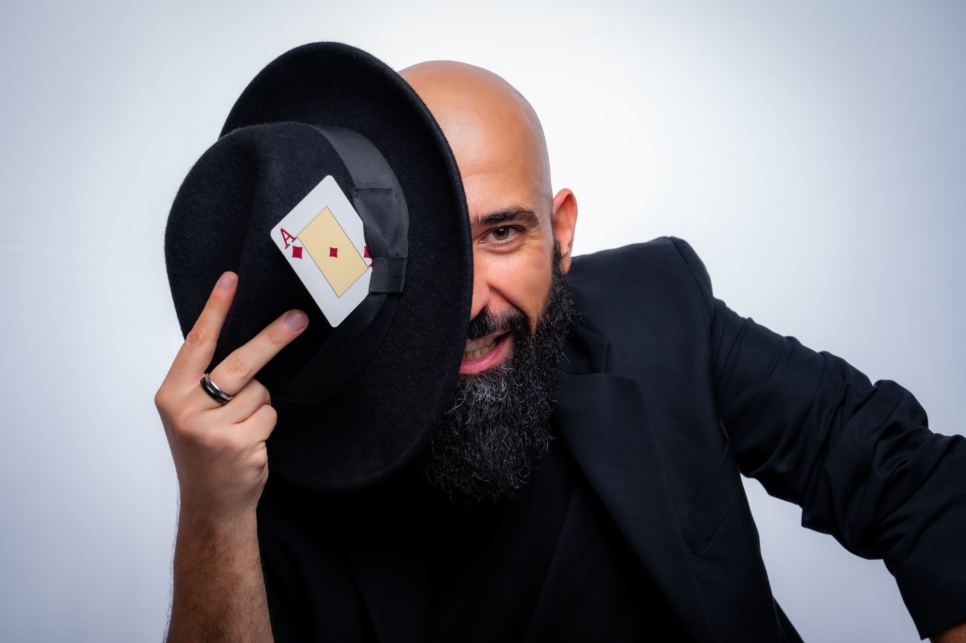 Foto de estudio chico con sombrero negro y carta de pocker