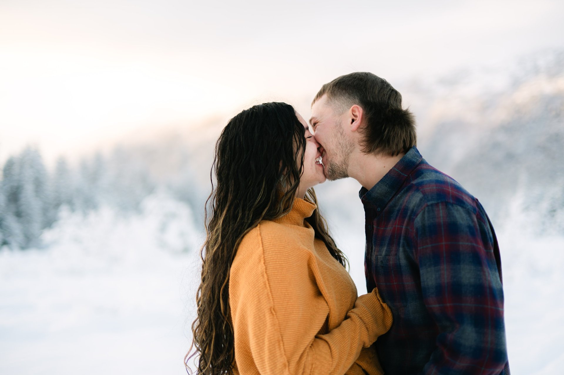a man and woman kissing in the snow